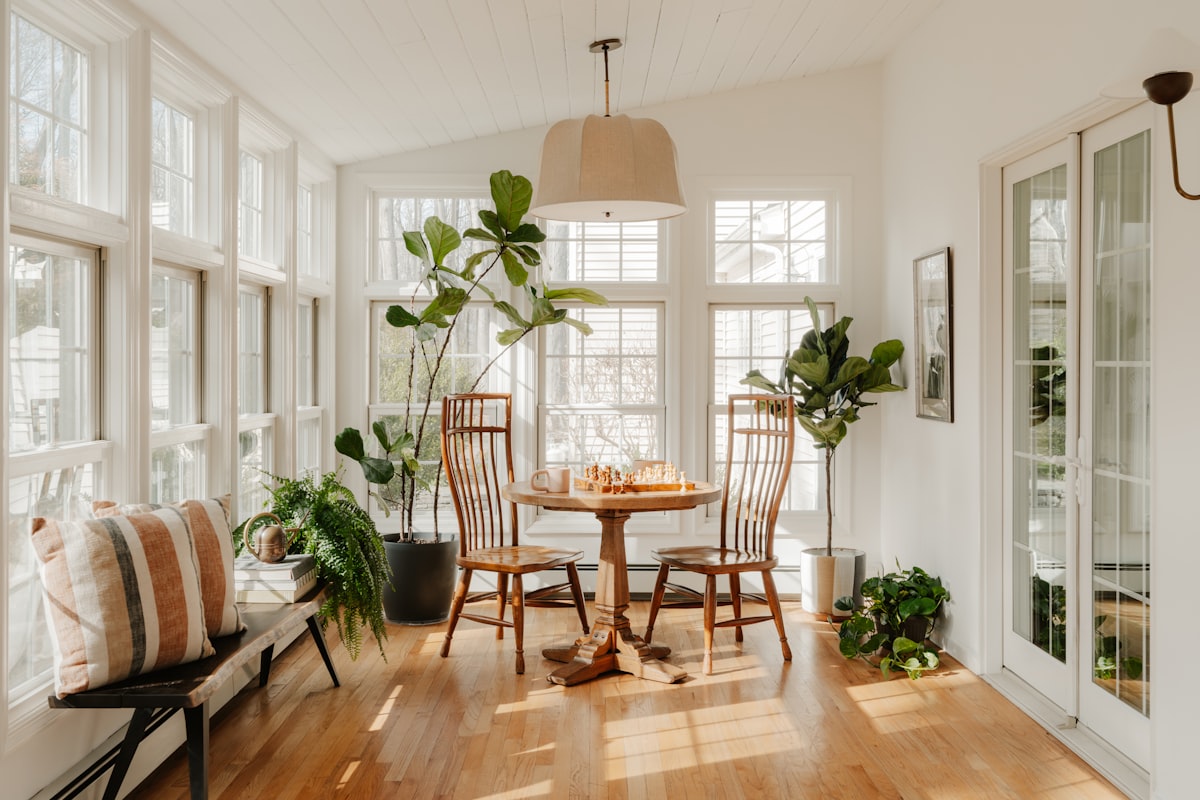 Bright, comfortable conservatory dining room with plants